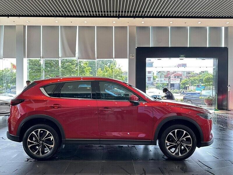Một mẫu xe máy điện nhập khẩu chính hãng với thiết kế hiện đại, đường nét góc cạnh và màu sắc ấn tượng, đỗ trước một tòa nhà hiện đại, thể hiện sự kết hợp giữa công nghệ và thẩm mỹ.